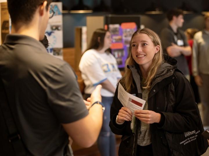 A prospective student attends an open house and has a discussion with a student ambassador